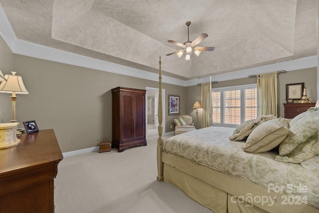 bedroom with lofted ceiling, a raised ceiling, ceiling fan, ornamental molding, and light colored carpet