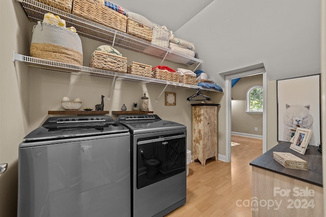 washroom featuring washing machine and clothes dryer and light hardwood / wood-style floors