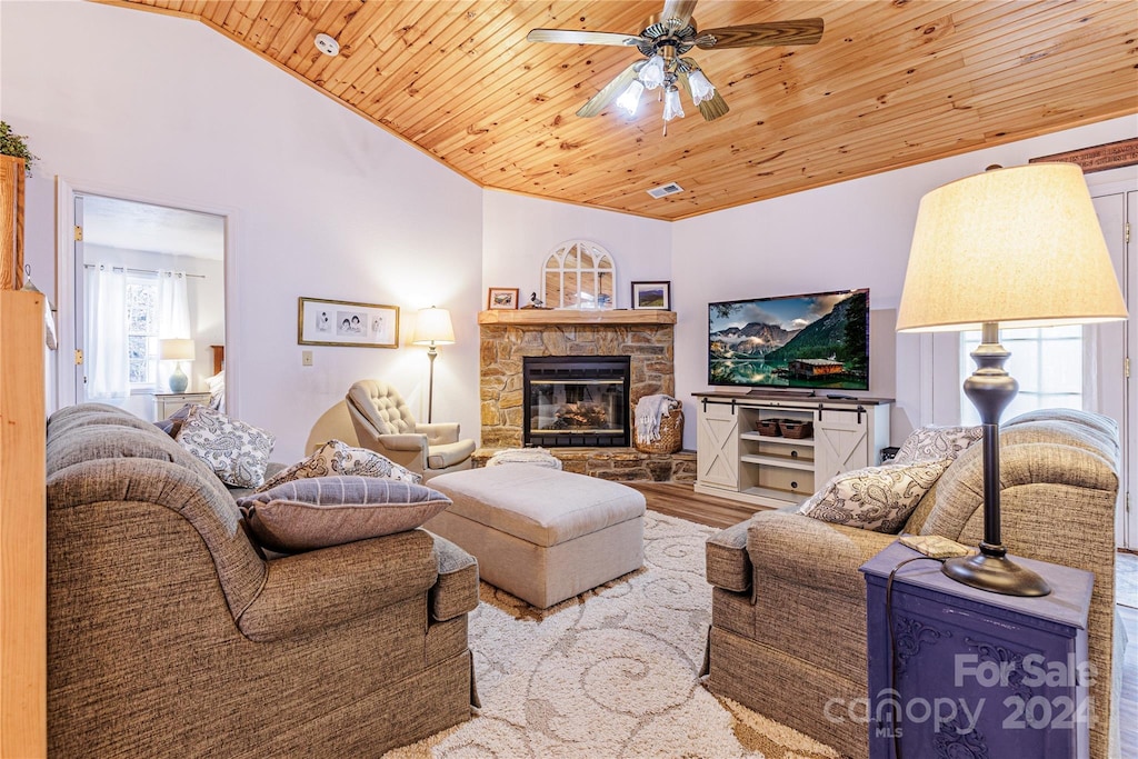 living room with a fireplace, light wood-type flooring, vaulted ceiling, and wood ceiling