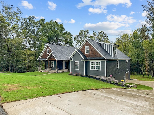 craftsman house featuring a front yard and a garage