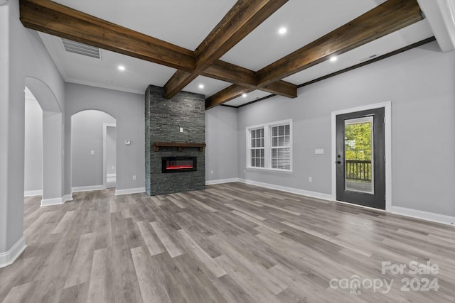 unfurnished living room with beam ceiling, a stone fireplace, light hardwood / wood-style floors, and coffered ceiling