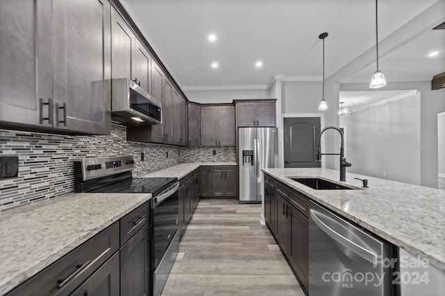 kitchen with decorative backsplash, light stone counters, dark brown cabinetry, stainless steel appliances, and sink