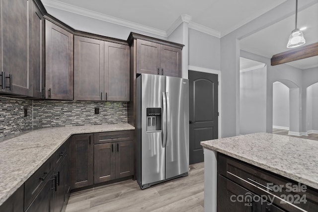 kitchen with dark brown cabinetry, stainless steel fridge with ice dispenser, light stone counters, backsplash, and pendant lighting