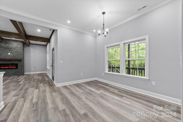 unfurnished dining area with coffered ceiling, beam ceiling, a chandelier, a fireplace, and light hardwood / wood-style floors