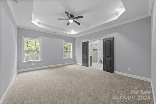 unfurnished bedroom with a raised ceiling, ceiling fan, light carpet, and ornamental molding