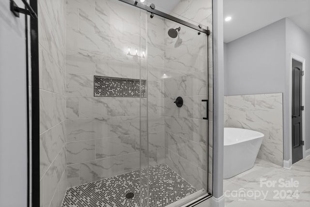 bathroom featuring independent shower and bath and tile walls