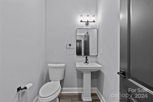 bathroom with hardwood / wood-style flooring and toilet