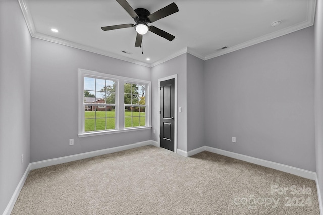 carpeted empty room featuring ceiling fan and crown molding