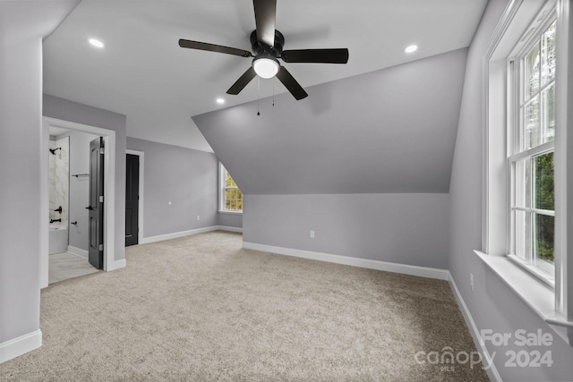 additional living space featuring light carpet, ceiling fan, and vaulted ceiling