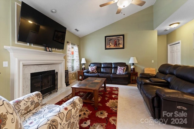 tiled living room featuring vaulted ceiling, ceiling fan, and a premium fireplace