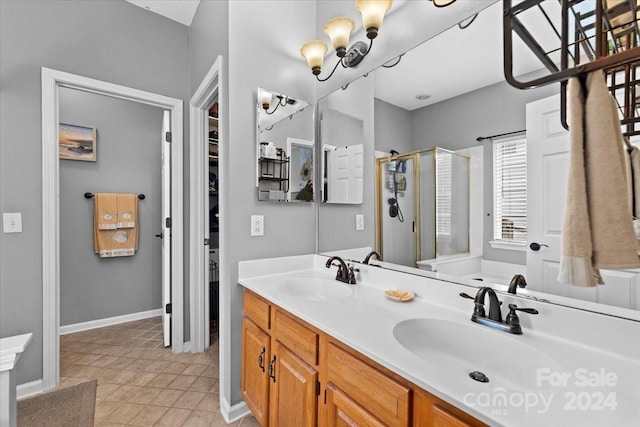 bathroom with tile patterned floors, a shower with door, and vanity