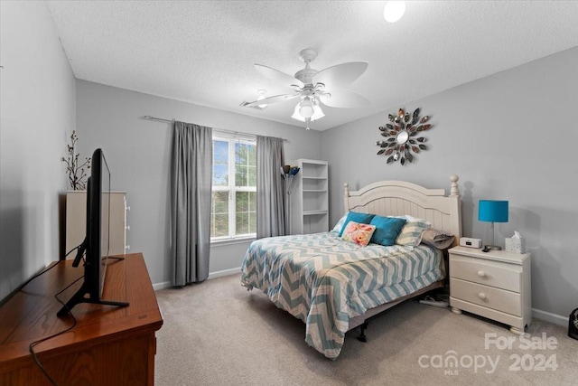 bedroom featuring ceiling fan, light colored carpet, and a textured ceiling