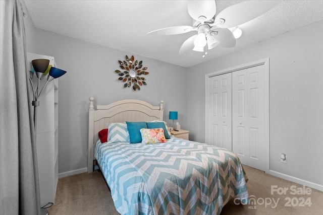 carpeted bedroom with ceiling fan, a textured ceiling, and a closet