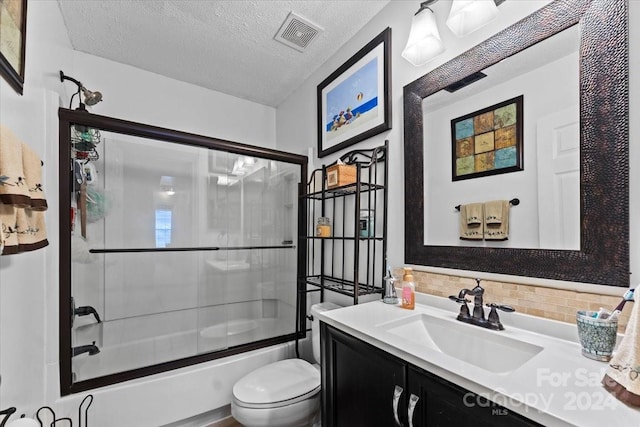 full bathroom featuring backsplash, bath / shower combo with glass door, vanity, a textured ceiling, and toilet