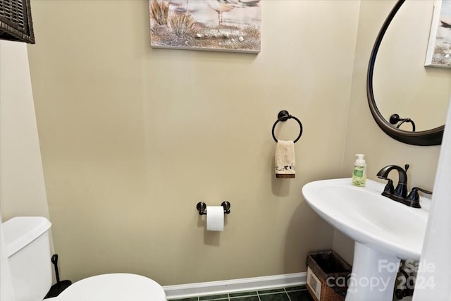 bathroom featuring sink, tile patterned flooring, and toilet