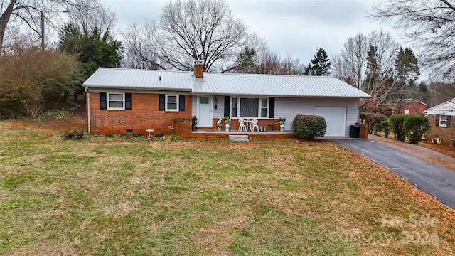 ranch-style home with covered porch, a garage, and a front yard