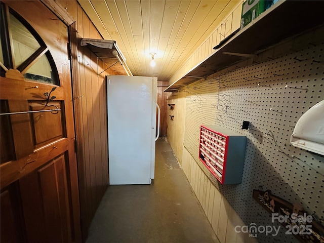 interior space featuring wooden ceiling, wooden walls, and concrete flooring