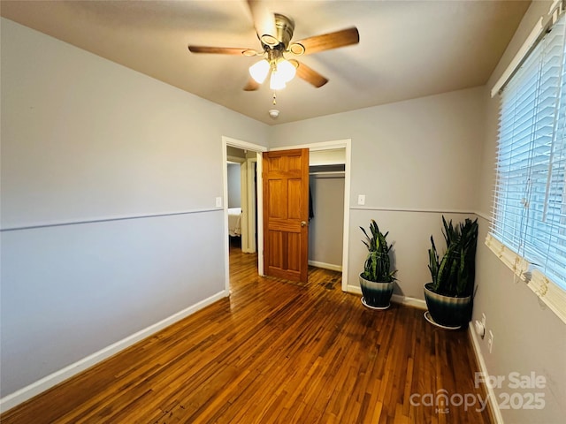 interior space featuring a closet, wood finished floors, a ceiling fan, and baseboards