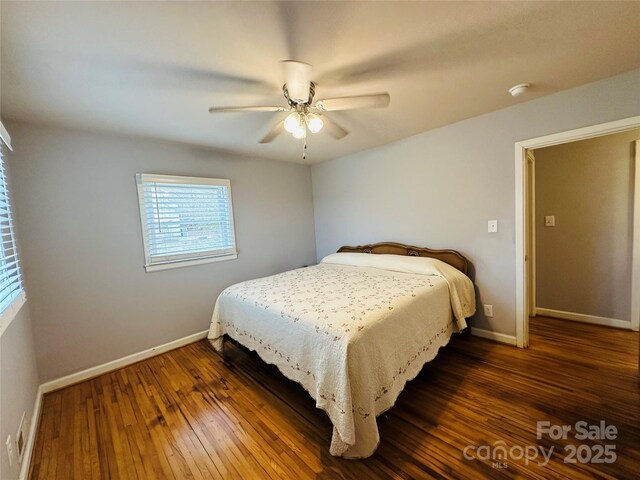 bedroom with dark wood-style floors, ceiling fan, and baseboards