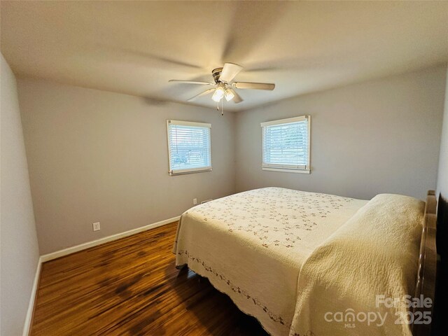 bedroom featuring ceiling fan, dark wood-type flooring, and baseboards