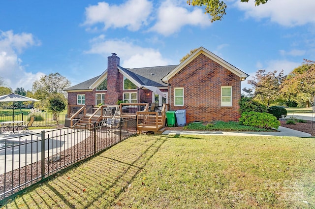 back of property with a deck and a lawn