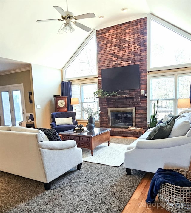 living room with a fireplace, hardwood / wood-style flooring, ceiling fan, and a healthy amount of sunlight