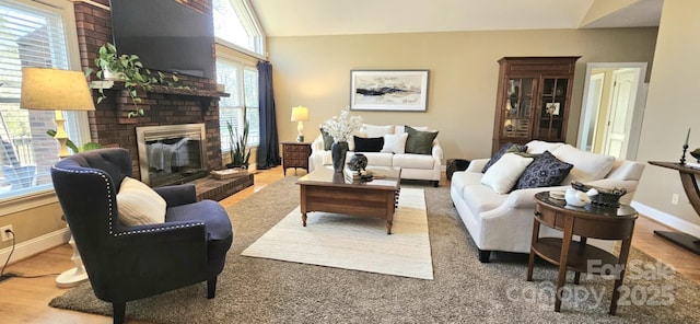 living room with a fireplace, hardwood / wood-style floors, and vaulted ceiling