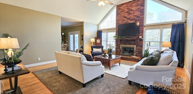 living room featuring ceiling fan, high vaulted ceiling, hardwood / wood-style floors, a fireplace, and ornamental molding