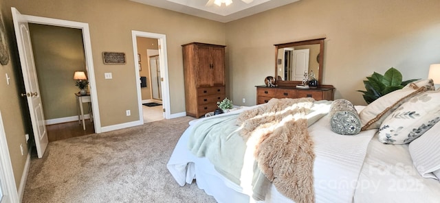 bedroom with ceiling fan, light colored carpet, and ensuite bathroom