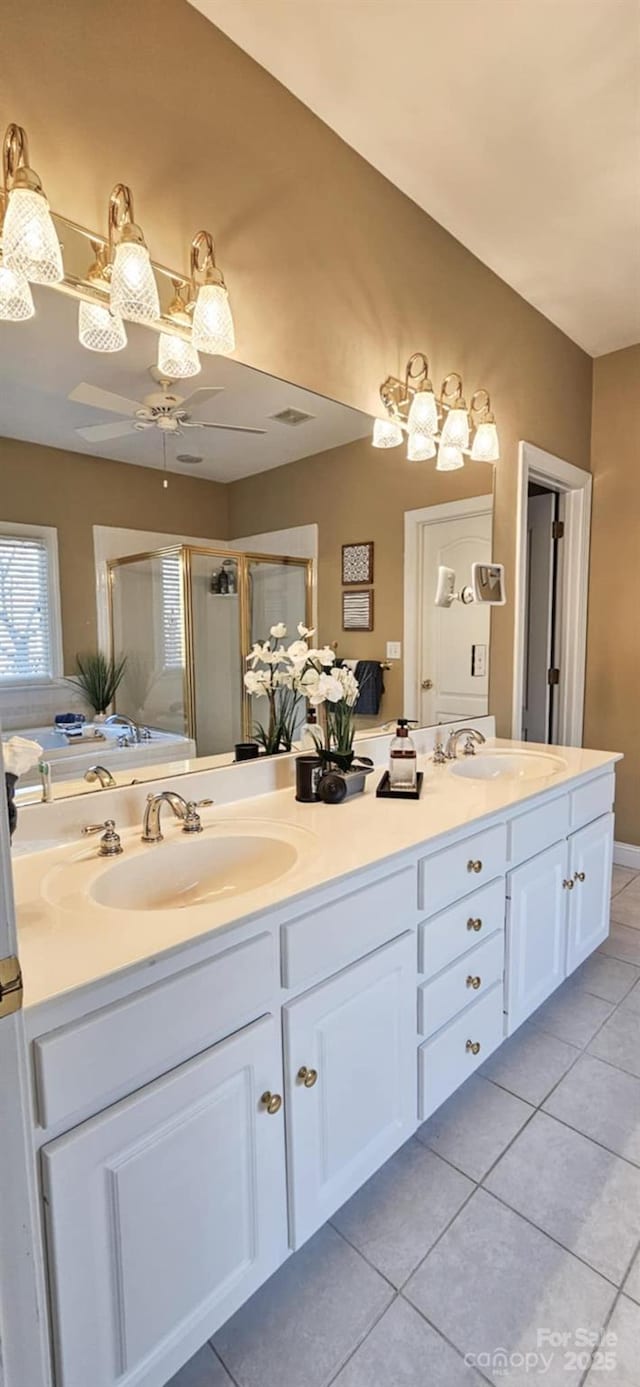 bathroom with tile patterned flooring, vanity, ceiling fan, and an enclosed shower