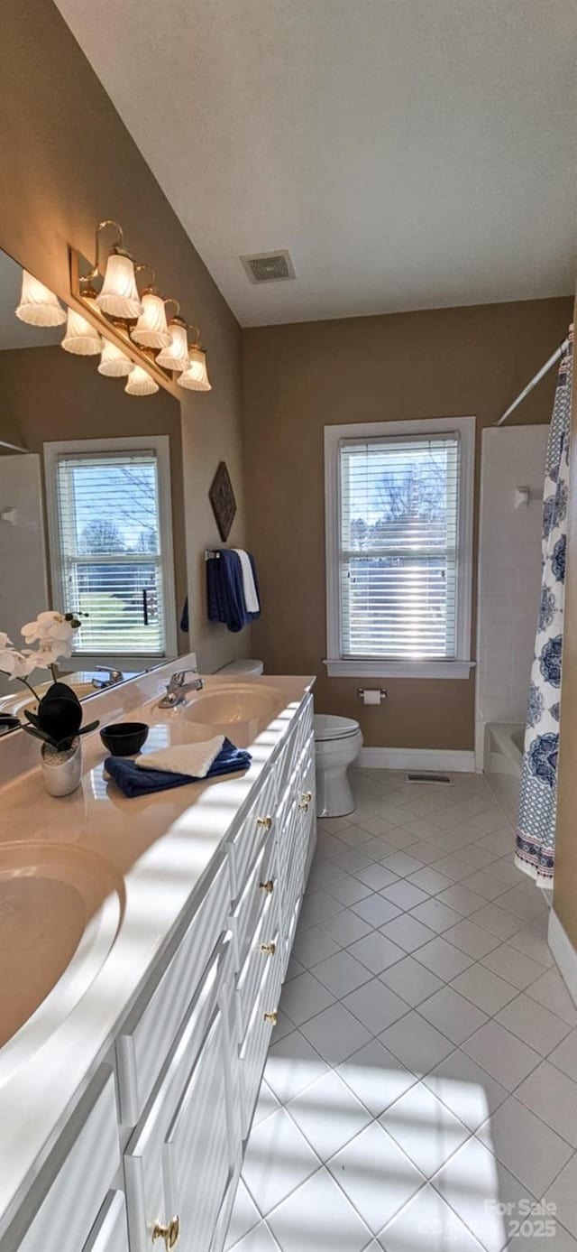 full bathroom featuring tile patterned flooring, vanity, plenty of natural light, and toilet