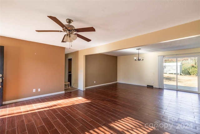 empty room with ceiling fan with notable chandelier