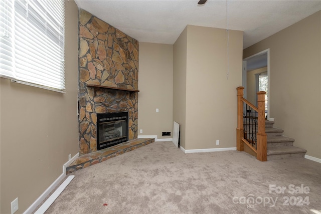 unfurnished living room with a fireplace and carpet