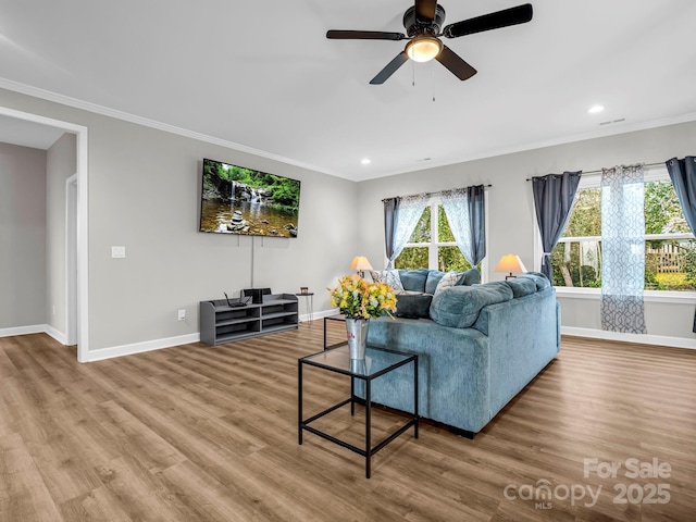 living room with ornamental molding, hardwood / wood-style floors, and ceiling fan