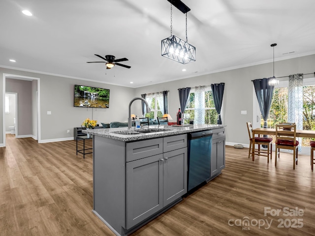 kitchen featuring gray cabinets, a sink, dishwashing machine, and wood finished floors