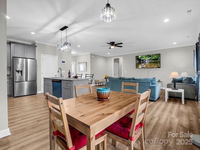 dining space featuring light wood-style floors, ornamental molding, and recessed lighting