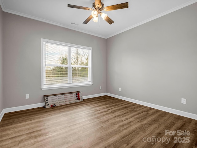 unfurnished room with baseboards, visible vents, a ceiling fan, ornamental molding, and wood finished floors