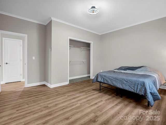 bedroom with crown molding, light wood-type flooring, and a closet