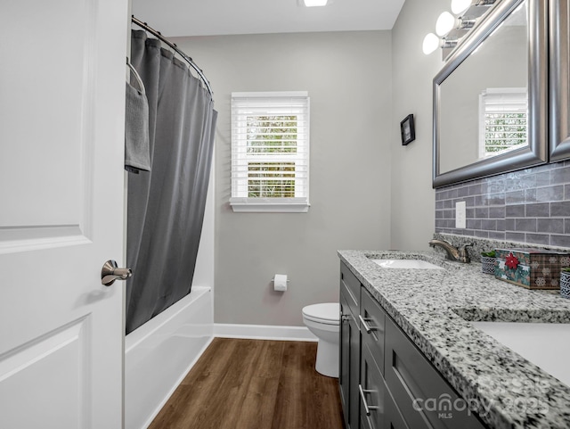 full bathroom with shower / tub combo with curtain, plenty of natural light, tasteful backsplash, vanity, and wood-type flooring