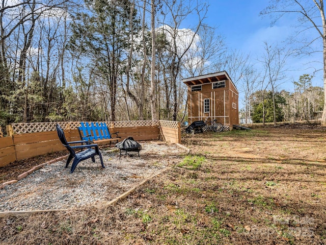 view of yard with a storage shed and an outdoor fire pit