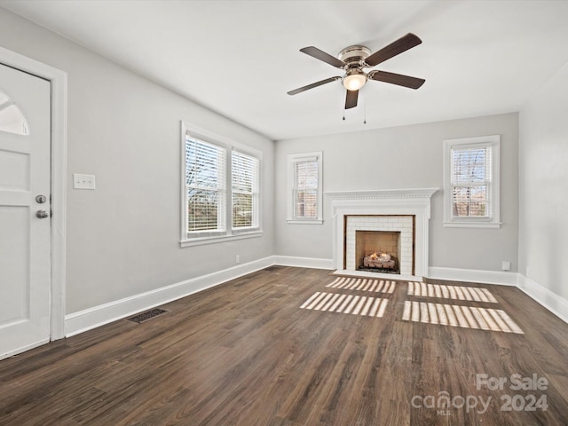 unfurnished living room featuring dark hardwood / wood-style floors, ceiling fan, and a fireplace