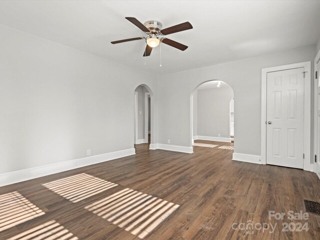 spare room featuring ceiling fan and dark wood-type flooring