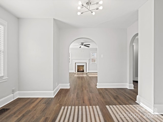 hallway featuring dark hardwood / wood-style flooring, a healthy amount of sunlight, and a notable chandelier