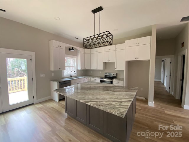 kitchen with light stone counters, a kitchen island, stainless steel electric range, white cabinets, and dishwasher