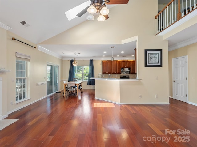 9903 Southampton Commons Dr, Charlotte, NC 28277 - kitchen featuring brown cabinetry, a ceiling fan, dark wood-style flooring, ornamental molding, and a skylight
