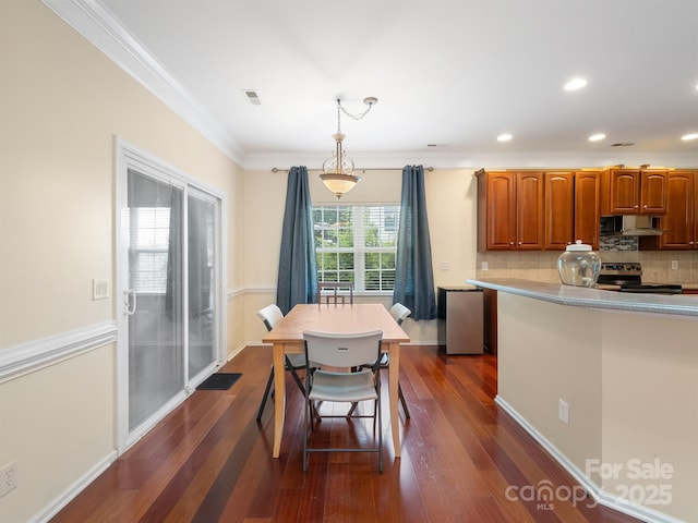 9903 Southampton Commons Dr, Charlotte, NC 28277 - kitchen featuring stainless steel range with electric cooktop, wall chimney exhaust hood, crown molding, decorative backsplash, and dark wood-type flooring