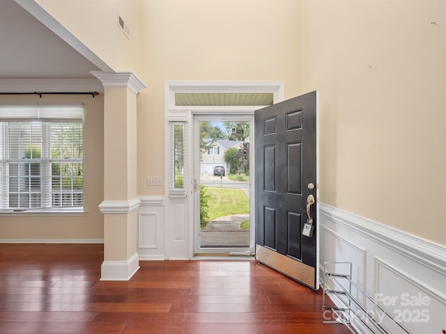 9903 Southampton Commons Dr, Charlotte, NC 28277 - entrance foyer with decorative columns, a wainscoted wall, hardwood / wood-style floors, a high ceiling, and a decorative wall