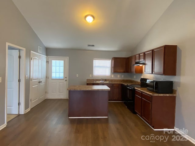 kitchen with dark hardwood / wood-style flooring, a center island, black appliances, and lofted ceiling