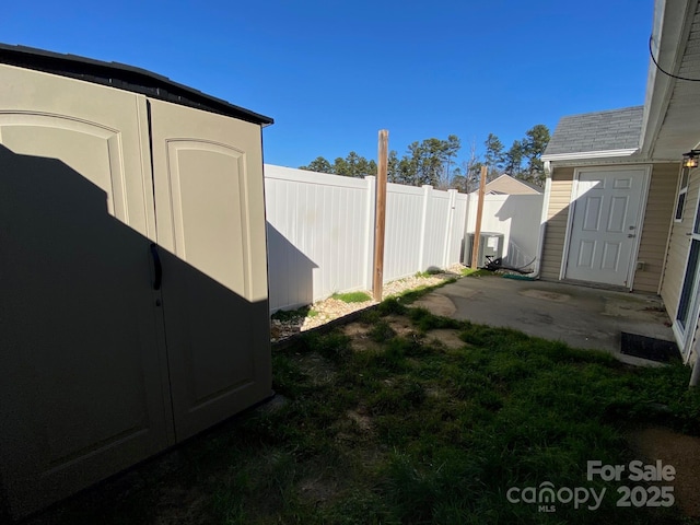 view of yard with a storage unit, cooling unit, and a patio area