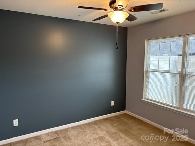 spare room featuring ceiling fan and light colored carpet